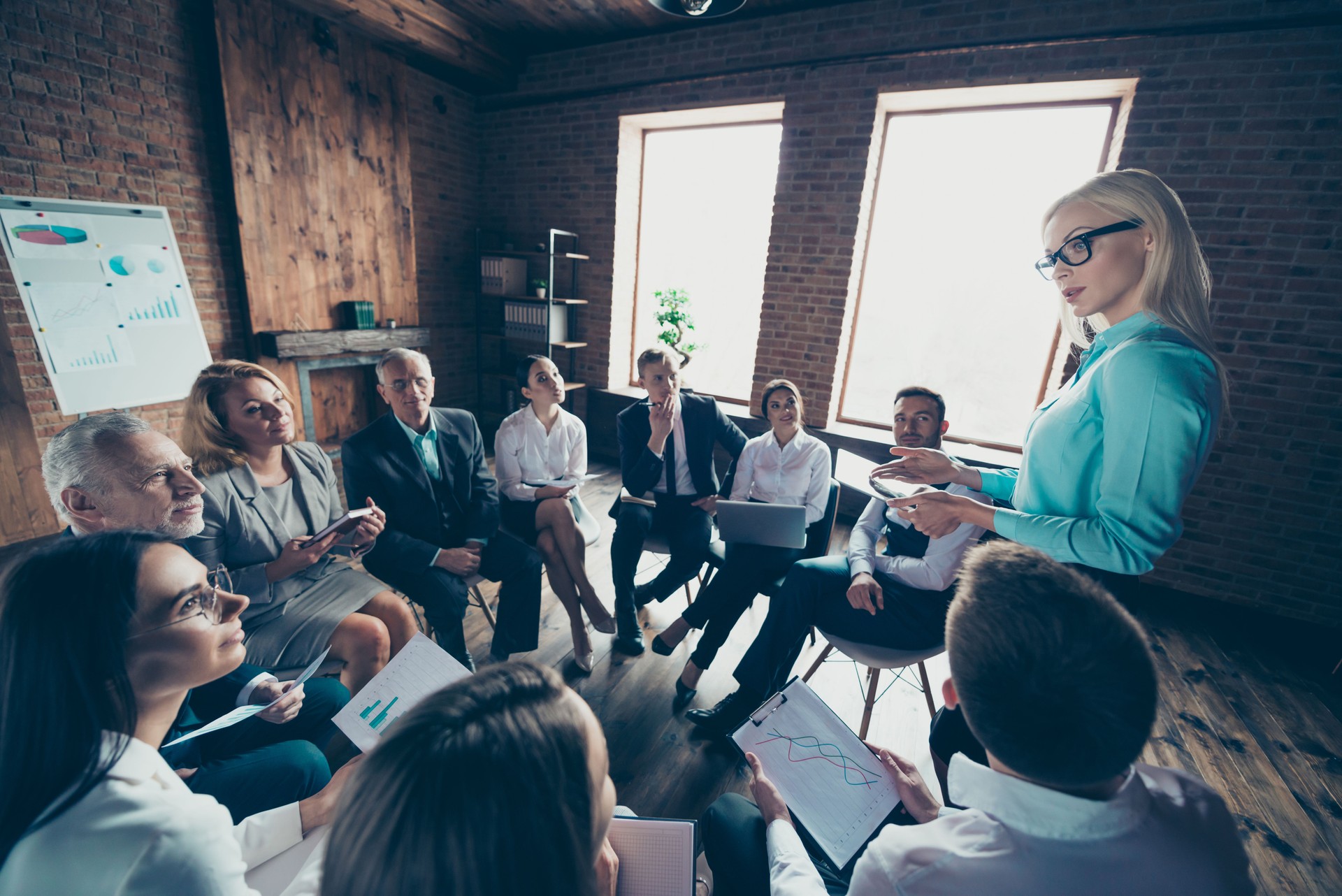 Elegant classy chic stylish trendy professional business people sitting in circle talking speaking discussing presenter speaker company management presenting report at work place station